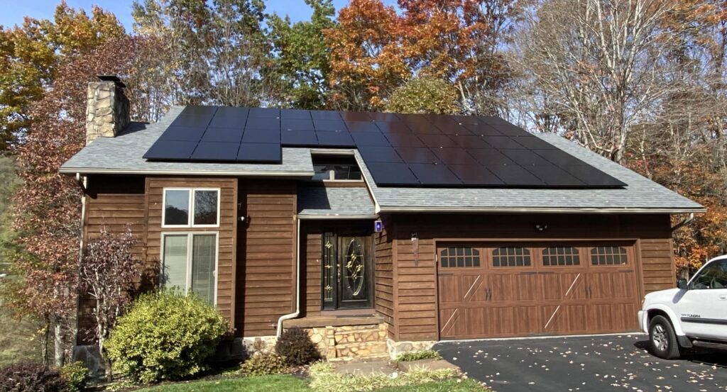 Home with solar panels surrounded by fall foliage